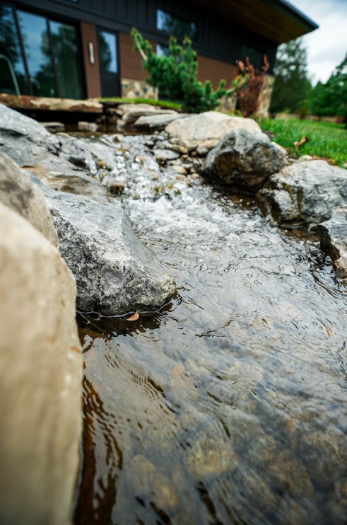 A combination of 1-watt, 3-watt, and 6-watt landscape and underwater lights highlights key areas of the pond, bubbling rocks, and waterfall system. Rather than illuminating every inch of the water equally, different fixtures help emphasize movement, stone, and focal points throughout the property.