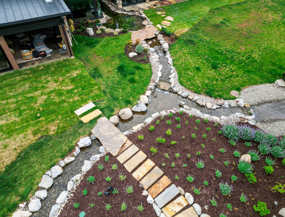 Coping boulders were deliberately positioned both above and below the waterline to eliminate the appearance of an artificial edge. Larger statement boulders were reserved for the bubbling rock features and waterfalls, while approximately 3 to 5-inch river rock was secured along the pond walls.