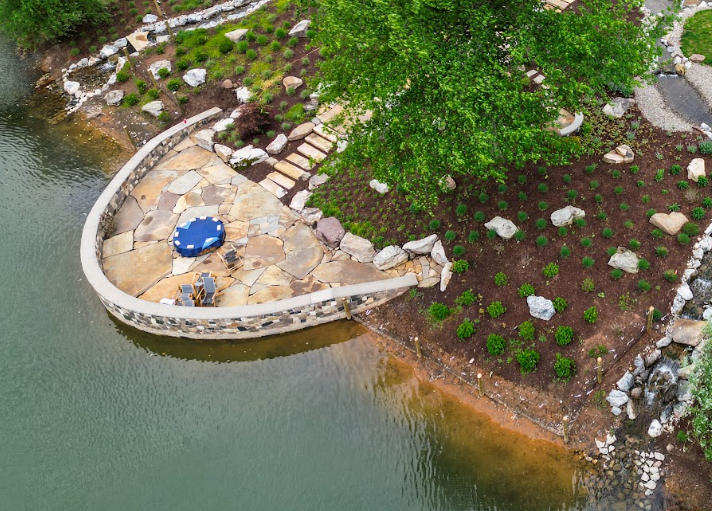 The fire pit sits between the two branches of moving water, maintaining views of the stream from either side and surrounding the gathering area with the sound of rushing water.